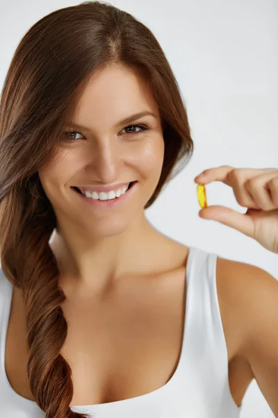 Nutrición. Un estilo de vida saludable. Mujer sosteniendo la píldora con aceite de pescado O — Foto de Stock