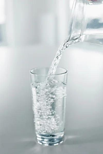 Acqua potabile. Versare l'acqua dalla brocca in un bicchiere. Salute, Di — Foto Stock