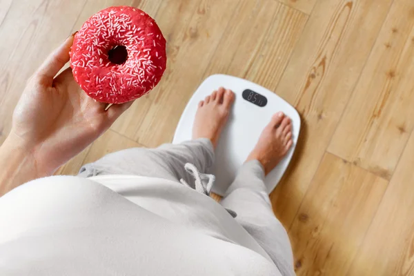 Diet. Woman On Weighing Scale, Holding Donut. Unhealthy Food. Ob — 图库照片