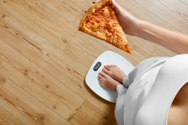 Dieet, Fast Food. Vrouw op schaal houden pizza. Obesitas. — Stockfoto