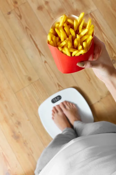 Dieta, comida rápida. Mujer a escala, papas fritas. Obesidad . —  Fotos de Stock