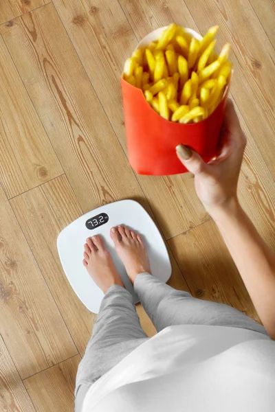 Dieta, comida rápida. Mujer a escala, papas fritas. Obesidad . —  Fotos de Stock