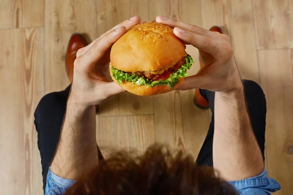 Mangiare fast food. Hands Holding Hamburger. Punto di vista. Nutrito — Foto Stock