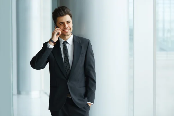 Homme d'affaires parlant au téléphone et souriant — Photo