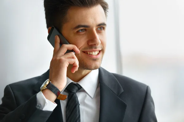 Homme d'affaires parlant au téléphone et souriant — Photo