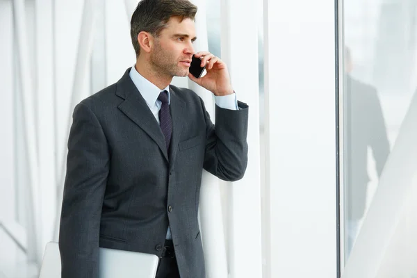 Mosolygó üzleti ember beszél-a mozgatható telefon — Stock Fotó