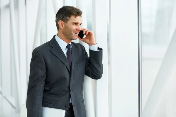 Cep telefonu üzerinde konuşurken gülümseyen iş adamı — Stok fotoğraf