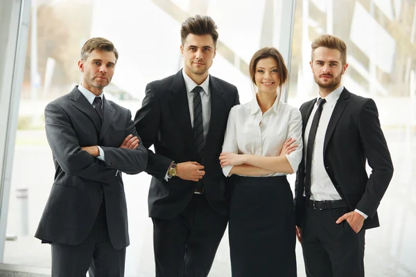 Бизнес команда. Счастливые улыбающиеся люди, стоящие в ряд в офисе — стоковое фото
