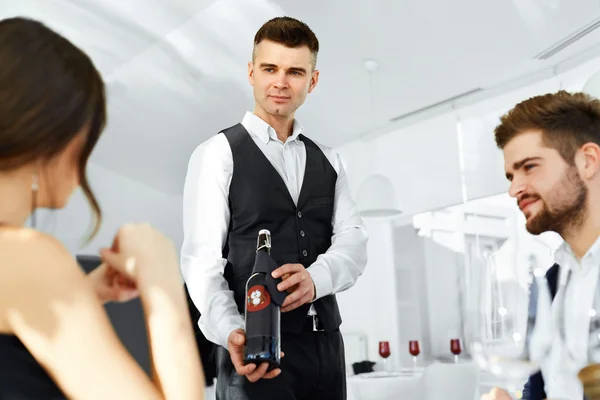 официант с вином. Guests bringing wine. Bringing wine. официантка несет вино. форма сомелье.