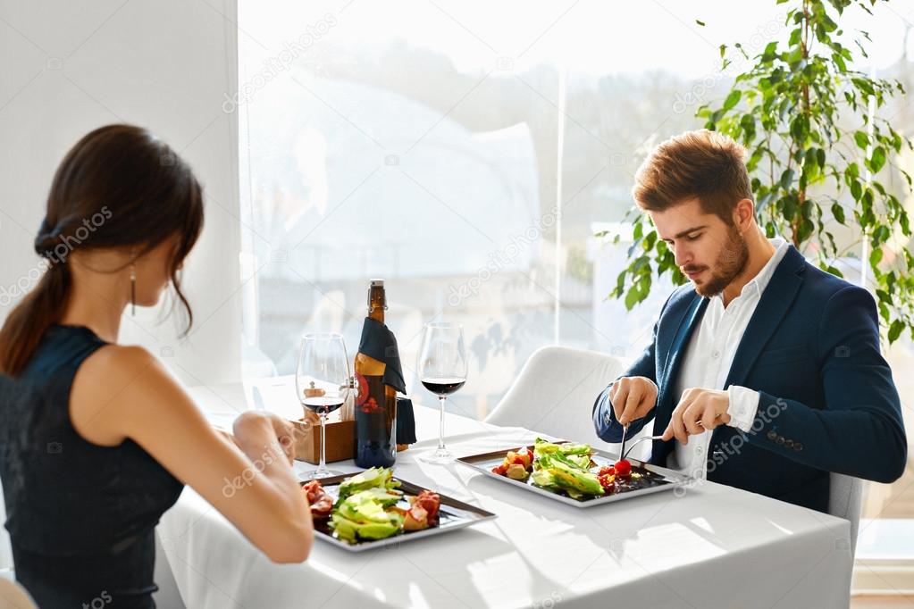 Healthy Food. Couple Eating Caesar Salad For Meal In Restaurant.