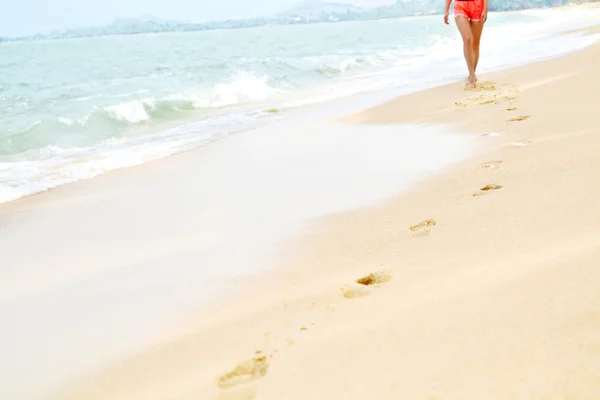Женщина ходит по пляжу, следы на песке. Здоровый образ жизни. Ж — стоковое фото