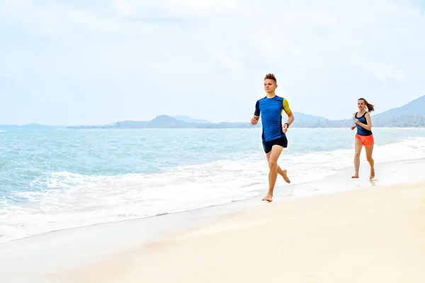 Un estilo de vida saludable. Pareja atlética corriendo en la playa. Deportes, Fit — Foto de Stock