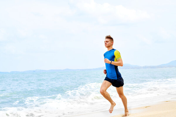 Велнесс. Fit Athletic Man Running On Beach, Jogging During Worko
