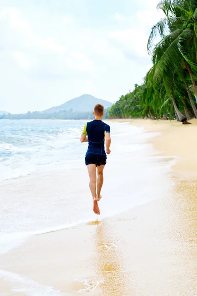 Corre. Hombre atlético en forma corriendo en la playa. Haciendo ejercicio. Vida saludable — Foto de Stock