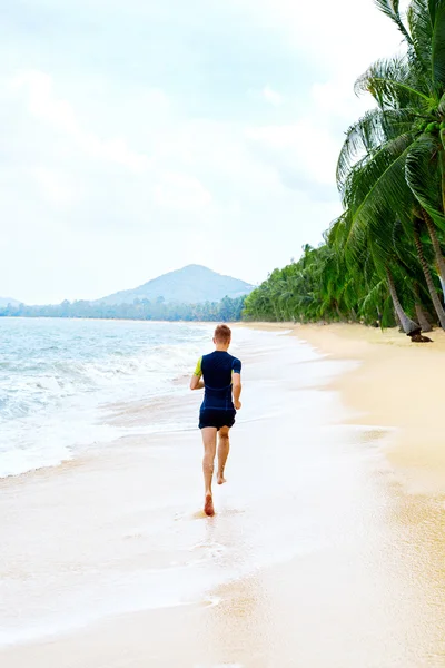 Corre. Hombre atlético en forma corriendo en la playa. Haciendo ejercicio. Vida saludable — Foto de Stock