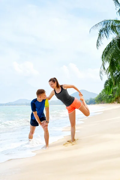 Un estilo de vida saludable. Atleta estiramiento, ejercicio en la playa. Fitn. —  Fotos de Stock