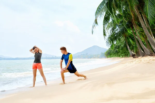 Un estilo de vida saludable. Atleta estiramiento, ejercicio en la playa. Fitn. — Foto de Stock