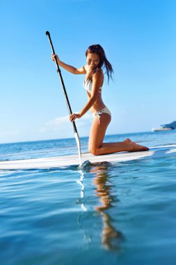 Recreational Water Sports. Woman Paddling On Surf Board. Summer 