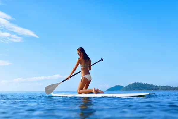 Esportes aquáticos recreativos. Paddling de mulher na prancha de surf. Verão — Fotografia de Stock