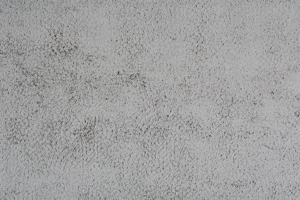 Abstract background in the form of white concrete, close-up with black inclusions Patterned pattern on concrete. Smeared concrete.