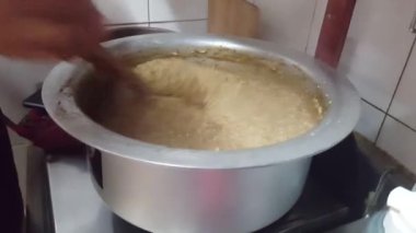 Kichra adı verilen geleneksel Pakistan beyaz pirincini ahşap spatula ya da tencere eşyasıyla pişirmenin yakın görüntüsü. Geleneksel Charsadda tarifi Pakistan 'daki leziz lezzetleriyle ünlüdür.
