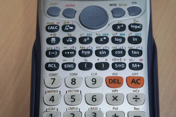 Calculator Met Gekleurde Toetsen Knoppen Geïsoleerd Een Houten Achtergrond — Stockfoto