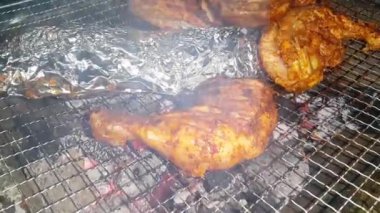 Barbekü ızgarasında yanan kömürlere yakın çekim. Kömür yanmaya başladı. Metal ızgarada bir akşam parlayan kömürün yakın çekimi