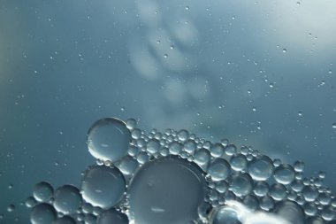 Su yüzeyinde yüzen petrol çemberlerinin soyut makro arka planı. Makro, su üzerindeki baloncukları yakından görüyor. Su makro fotoğraf arkaplanında yağ kabarcıkları