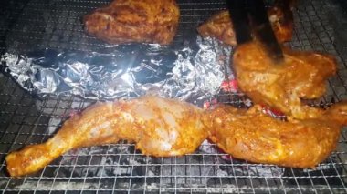 Barbekü ızgarasında yanan kömürlere yakın çekim. Kömür yanmaya başladı. Metal ızgarada bir akşam parlayan kömürün yakın çekimi