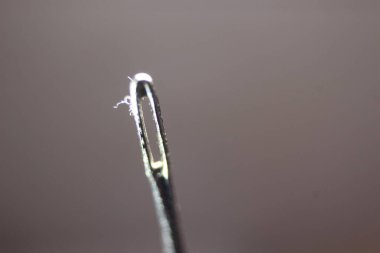 Dikiş iğnesinin makro fotoğrafı. Siyah arkaplan üzerinde izole edilmiş boş göz dirseği ile küçük iğne.