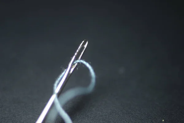 ミシン針のマクロ写真 黒の背景の上に隔離された アイレットの糸で小さな針 — ストック写真
