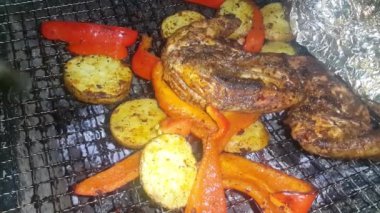 Barbekü ızgarasında yanan kömürlere yakın çekim. Kömür yanmaya başladı. Metal ızgarada bir akşam parlayan kömürün yakın çekimi