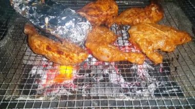 Barbekü ızgarasında yanan kömürlere yakın çekim. Kömür yanmaya başladı. Metal ızgarada bir akşam parlayan kömürün yakın çekimi