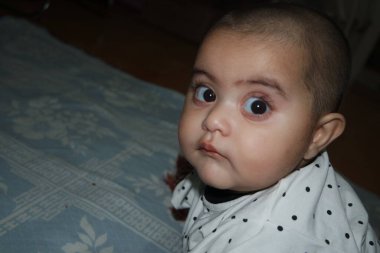 Güzel yüzlü, büyük gözlü ve sevimli yüzlü küçük kız. Bebek tatlı aktiviteler yapıyor.