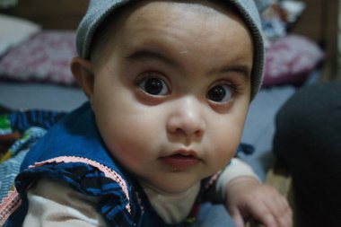 Güzel yüzlü, büyük gözlü ve sevimli yüzlü küçük kız. Bebek tatlı aktiviteler yapıyor.