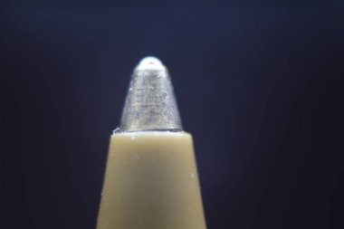 Koyu gri arka planlı tükenmez kalem uçlu makro fotoğraf. Gri arkaplanda metal tükenmez kalemin uç makro görüntüsü.