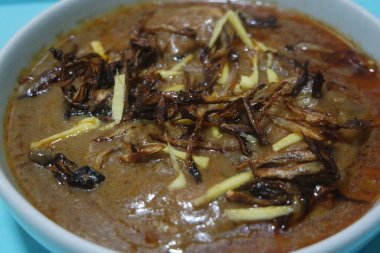 Salata ve limon suyu ile geleneksel Pakistan Haleem yemeğinin yakın görüntüsü.