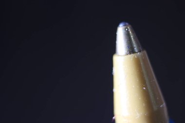 Koyu gri arka planlı tükenmez kalem uçlu makro fotoğraf. Gri arkaplanda metal tükenmez kalemin uç makro görüntüsü.