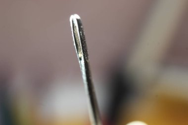 Dikiş iğnesinin makro fotoğrafı. Siyah arkaplan üzerinde izole edilmiş boş göz dirseği ile küçük iğne.