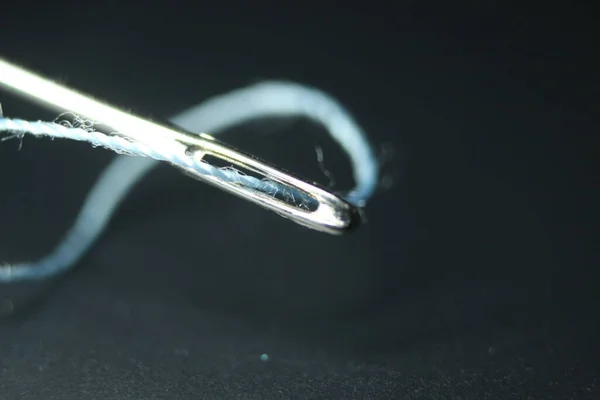 ミシン針のマクロ写真 黒の背景の上に隔離された アイレットの糸で小さな針 — ストック写真