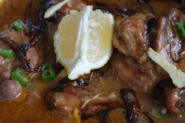 Salata ve limon suyu ile geleneksel Pakistan Haleem yemeğinin yakın görüntüsü.