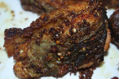 Beyaz arka planda kızarmış balık filetosunun baharatlı ve çıtır çıtır barbeküsü. Sağlıklı beslenme için ev yapımı alabalık bifteği..