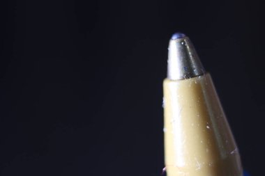 Koyu gri arka planlı tükenmez kalem uçlu makro fotoğraf. Gri arkaplanda metal tükenmez kalemin uç makro görüntüsü.
