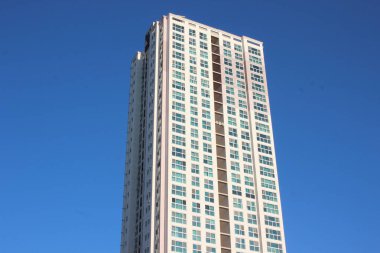 Güneşli bir günde mavi gökyüzü olan bir gökdelenin geniş açılı manzarası..