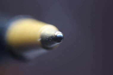 Koyu gri arka planlı tükenmez kalem uçlu makro fotoğraf. Gri arkaplanda metal tükenmez kalemin uç makro görüntüsü.