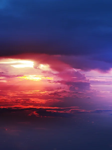 Sunset above clouds from airplane window — Stock Photo, Image