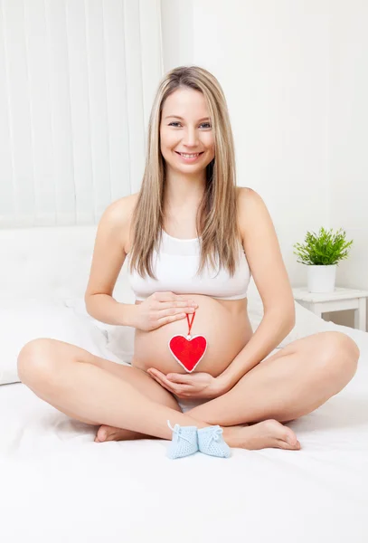 Těhotná žena relaxaci na lůžku — Stock fotografie