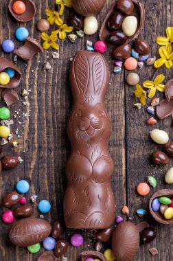 Çikolata Paskalya yumurtaları ve tatlılar ahşap arka plan üzerinde