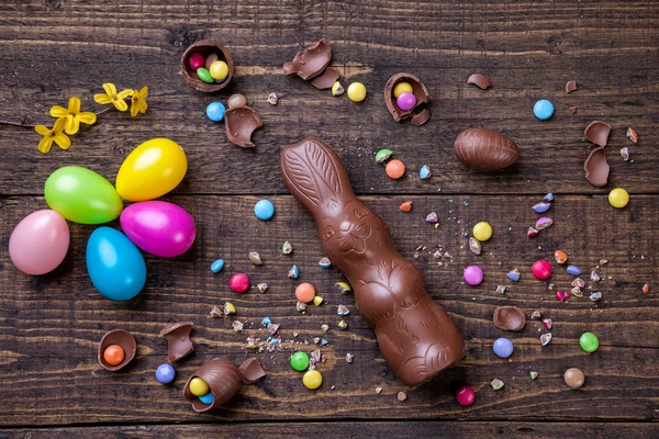Choklad påskägg och godis på trä bakgrund — Stockfoto