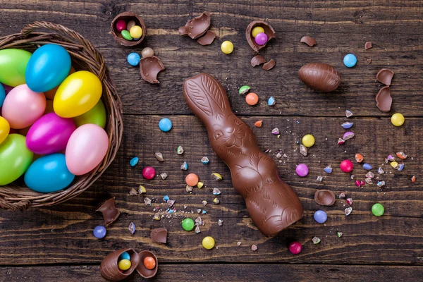 Oeufs de Pâques au chocolat et bonbons sur fond en bois — Photo